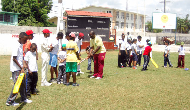  Coach Garvin Nedd teaching a few of the youngsters about holding the bat correctly 