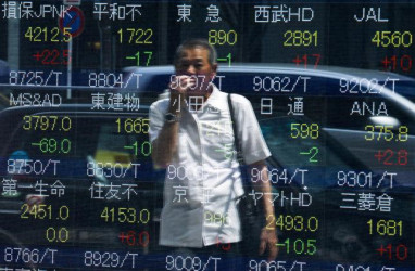 A man looks at stock prices displayed at a board showing market indices in Tokyo July 28, 2015. (Reuters/Thomas Peter) 