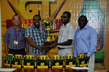 Tournament Coordinator Troy Mendonca (2nd left) collecting the championship trophy from Banks DIH Brand Manager Jeff Clement while Banks DIH Brand Manager of Beers Brian Cho-Hen (left) and Communications Director Troy Peters (right) look on following the launch of the inaugural GT Beer Futsal Tournament 