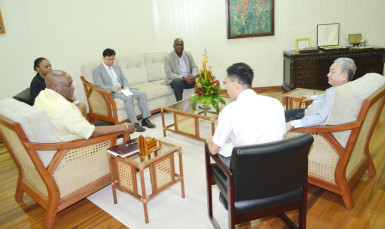 In this Ministry of the Presidency photo, Minister of State, Joseph Harmon is at left and Chinese Ambassador Zhang Limin is at right.