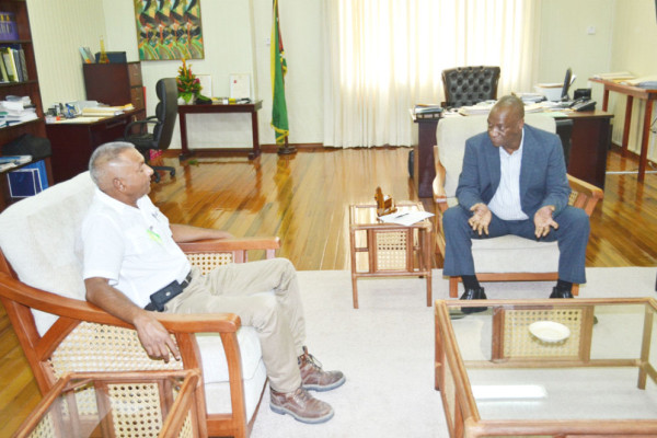 Dax Construction Company CEO Faizal Mohammed and Minister of State Joseph Harmon in discussion yesterday. (Ministry of the Presidency photo) 