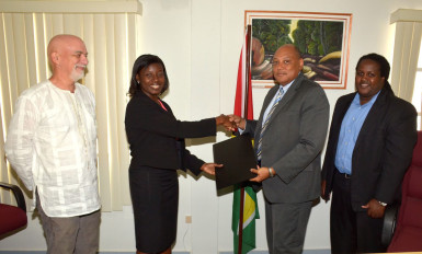 Minister of Governance Raphael Trotman (second from right) exchanging the MoU with Aiesha Williams, Head of Office, WWF Guianas. (Ministry of the Presidency photo) 