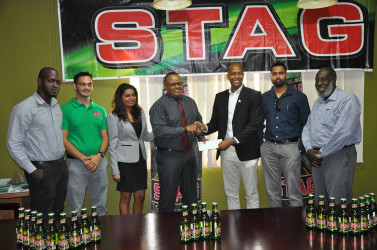 GFF Normalisation Committee Chairman Clinton Urling (3rd right) is all smiles as he collects the sponsorship cheque from Marketing Director of ANSA McAl Troy Cadogan (centre) following the latter’s announcement as the sponsor of the inaugural GFF Elite League while other members of the company and federation look on