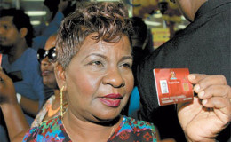 Cheryl Worrell displays her biometric Smart Card for the media during the launch of the Government’s latest social initiative at Xtra Foods Supermarket in Grand Bazaar, Valsayn.
