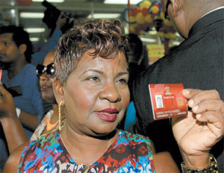 Cheryl Worrell displays her biometric Smart Card for the media during the launch of the Government’s latest social initiative at Xtra Foods Supermarket in Grand Bazaar, Valsayn. 