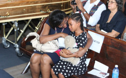 Crystal Hughes being consoled by Cathy Hughes at her grandmother’s thanksgiving service, which was held at the St. Andrew’s Kirk yesterday. (Photo by Keno George)