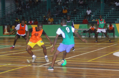Quincy Hemmerding (No.9) of Queen Street, Tiger Bay trying to evade the challenge of Festival City’s Keith Fletcher during their team’s matchup in the GT Beer Futsal Championship on Friday. 