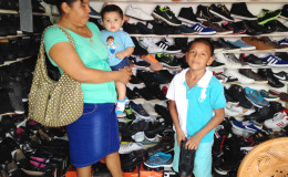  A mother purchasing footwear for her son