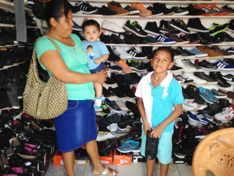  A mother purchasing footwear for her son