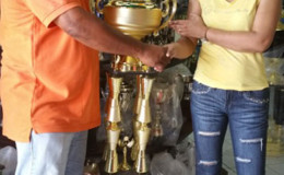 Organizer of the President’s Cup, Fazal Habibulla receiving the championship trophy yesterday from Devi Sunich.