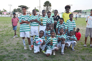 The newly crowned I-Net Communications u-13 champions Santos FC posing with their prizes following their win over hosts Fruta Conquerors at the Tucville Community ground. 