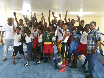 The boxers pose for a photo in the ring with president of the GBA Steve Ninvalle (extreme left) and Guyana’s lone Olympic medalist, Mike Parris (extreme right). 