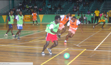 Queen Street Tiger Bay’s Jason Fredericks (green) in the process of initiating an attack while being pursued by several Agricola players during their exciting contest in the GT Beer Futsal Championship (photo by Orlando Charles) 
