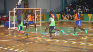 Deon Alfred of Sparta Boss (centre) denying an attempt on goal by Albouystown’s Roy Cassou (left) during their matchup in the GT Beer Futsal Championship. 