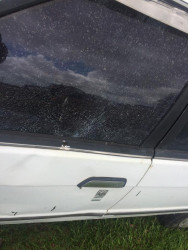 The car with the damaged window and bullet hole