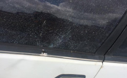 The car with the damaged window and bullet hole