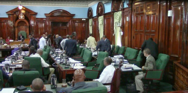Walkout: PPP/C MPs exiting the Parliament chamber yesterday for a caucus after the government successfully moved a motion limiting the number of days for the consideration of the budget estimates.  The MPs returned to the chamber shortly after. PPP/C MP Harry Gill is sitting at right. (Keno George photo)