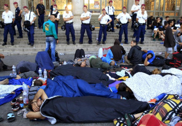 Migrants rest outside the main Eastern Railway station in Budapest, Hungary, September 2, 2015. REUTERS/Bernadett Szabo