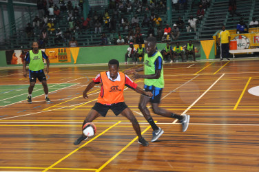 Okeene Fraser of Bent Street trying to maintain possession of the ball while being challenged by North Ruimveldt’s Joshua Browne during their group-D affair in the GT Beer Futsal Championship  