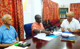 Minister of Communities Ronald Bulkan looks on as Permanent Secretary Emil McGarrell and Ashmins’ CEO Lennox John sign the US$300,000 agreement for the construction of a wastewater treatment plant. (Communities Ministry photo)