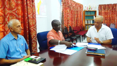 Minister of Communities Ronald Bulkan looks on as Permanent Secretary Emil McGarrell and Ashmins’ CEO Lennox John sign the US$300,000 agreement for the construction of a wastewater treatment plant. (Communities Ministry photo)