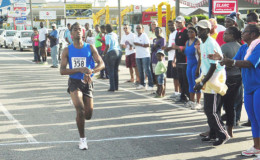 Flashback: Cleveland Forde victoriously crossing the finish line at last year’s Massy 10km event.