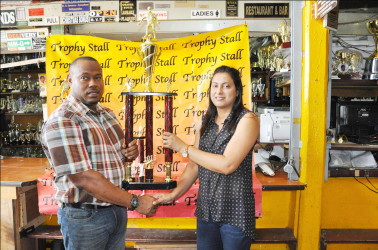 Petra Organization Co-Director and tournament coordinator Troy Mendonca (left) collecting the championship trophy from Trophy Stall’s Devi Sunich during the simple presentation ceremony 