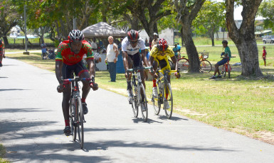 Junior Niles biking to victory ahead of Akeem Wilkinson and Shaquel Agard in a thrilling three-man sprint finish yesterday at the National Park. (Orlando Charles photo) 