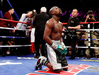 UNDEFEATED! Floyd Mayweather sinks to his knees in the middle of the ring following his final fight against Andre Berto Saturday night which he won to end his career unbeaten. (Fightnews photo) 