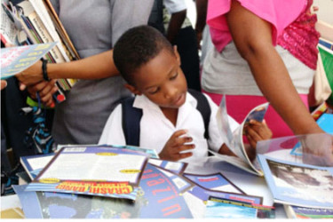 A student selects a book at the reading fair.