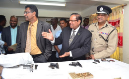 Prime Minister Moses Nagamootoo, Public Security Minister Khemraj Ramjattan and Police Commissioner Seelall Persaud during the inspection of the arms and ammunition collected under the current amnesty. (GINA photo)
