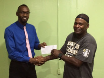 William France, (right) receiving his monetary support from Director of Sport yesterday. 