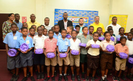 Members of the participating schools display their footballs which were donated by title sponsor Courts Guyana Incorporated alongside other members of the launch party inclusive of Director of Sports Christopher Jones (centre), Petra Organization Co-Director Troy Mendonca (4th from left) and Courts Guyana Inc. CEO Clyde De Hass (2nd from right) following the launch of the 4th annual Courts Pee Wee Football Tournament