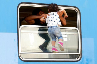  A migrant carries a child in a train at the station in Beli Manastir, Croatia September 18, 2015. (Reuters/Laszlo Balogh)