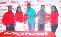 Chris Barnwell and Devendra Bishoo receive their ambassador contracts from Digicel executives Louanna Abrams and Vidya Sanichara as Rameshwhar Rupchand looks on.