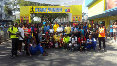 The top prize takers pose for a photo in front of Courts on Main Street following the fifth annual 10K and Fitness Run. 