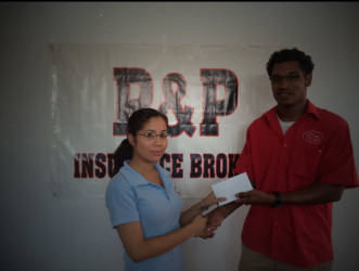 Milena Embleton of P & P Insurance Brokers Limited hands over the sponsorship to Dwain Dick, president of the Titans Table Tennis Club. 