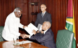 Commissioner Robeson Benn, receiving the Instrument of Office from President David Granger after he was sworn in on Tuesday (GINA photo)