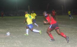 Chasing Pele: Pele’s Ronel Gordon (No.14) in the process of initiating an attack while being pursued by Alpha United’s Quincy Madramootoo (right) during their team’s 2-2 draw in the GFF Stag Beer Elite League at the GFC ground, Bourda on Wednesday. (Orlando Charles photo)