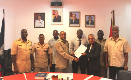  Commissioner of Police Seelall Persaud receives a copy of the “Rights of Arrested Persons” from Guyana Bar Association President Christopher Ram in the presence of several senior police officials. (Guyana Police Force photo)
