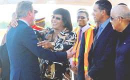 Prime Minister Portia Simpson Miller greets British Prime Minister David Cameron with a hug on his arrival at Norman Manley International Airport in Kingston on Tuesday. Looking on in the receiving line are Opposition Leader Andrew Holness (second right) and Minister of Water, Land, Environment and Climate Change Robert Pickersgill. (Photo/Jamaica Observer/Bryan Cummings)