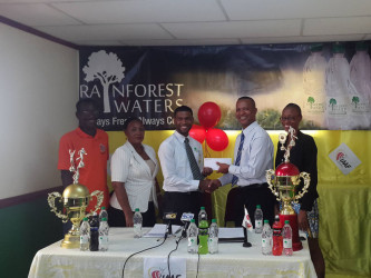 AAG President Aubrey Hutson (2nd from right) collects the sponsorship cheque from Banks DIH Limited Rainforest Waters and PowerAde Brand Manager Errol Nelson while other members of the launch party look on. 
