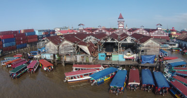 Downtime: Water taxis parked around the dilapidated Stabroek Market Wharf yesterday awaiting the afternoon rush hour. At serious risk to life and limb, several persons still vend on the wharf. (Photo by Keno George)