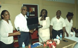 President David Granger (second from left) making the presentation of the laptop. (Ministry of the Presidency photo)