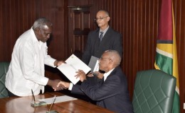 Robeson Benn (left) receiving his instrument of office from President David Granger (Ministry of the Presidency photo)