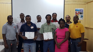 Participants pose with their certificates at the end of training, along with other bureau staff. 