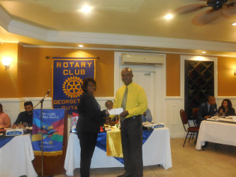 Elizabeth Cox, the President of the Rotary Club of Georgetown receiving a cheque from Brian Hackett, a Scotiabank representative, at the Cervical Cancer Campaign launch. 