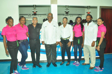 Owner of the Bistro Azure Ryan Fields (second, right), Minister of Finance Winston Jordan (fifth, right) and Owner of Giftland Mall, Roy Beepat, (third, left) pose for a photo with staff of the Bistro during its grand opening on Thursday night. 