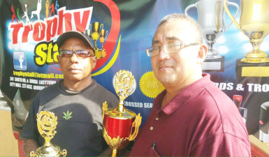 President of the GRFU, Peter Green (right) displays one of the trophies 