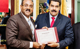  PM Gaston Browne (left) presents President Nicolas Maduro with the shares certificate for the oil company. (Office of the Antigua Prime Minister)